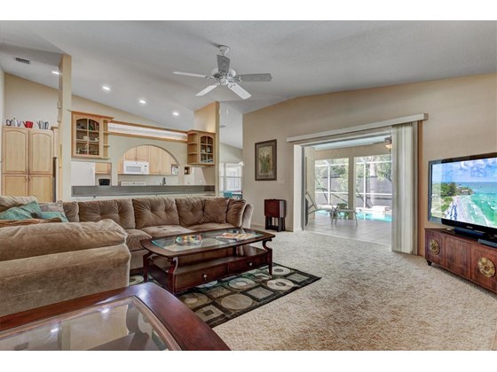 Family room with pocket sliders to pool area - Single Family Home for sale at 1518 Bel Air Star Pkwy, Sarasota, FL 34240 - MLS Number is A4506654